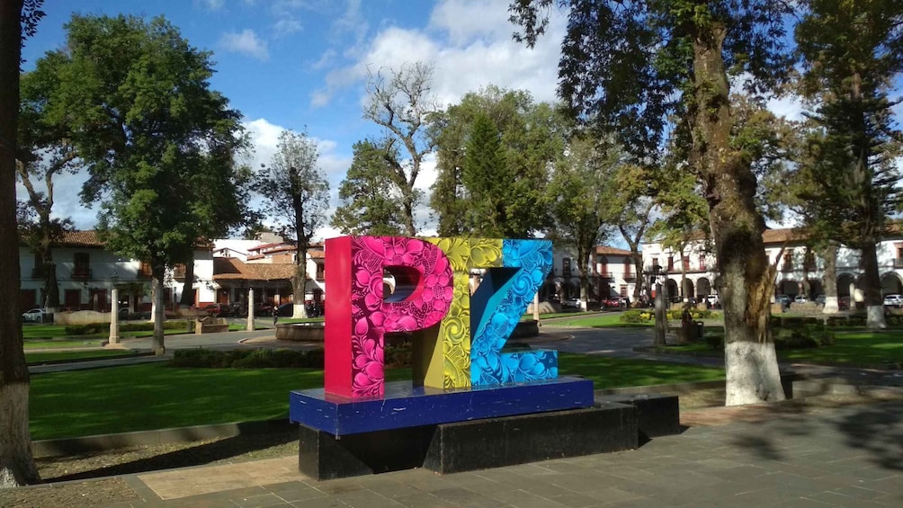A colorful sculpture with the letters 'PZ' in a park. 1