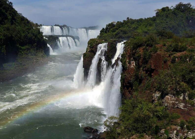 A multi-tiered waterfall with a rainbow in the mist. 2