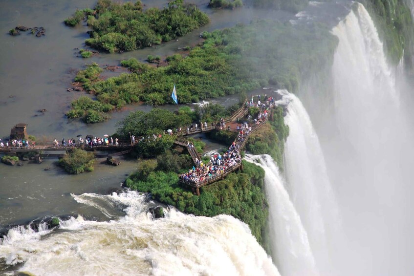 A large waterfall with a viewing platform and a bridge for visitors. 3