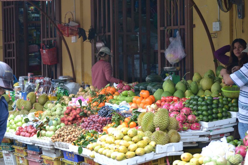A fruit market with various fruits like durians, dragon fruits, and apples. 3
