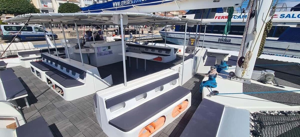 A marina with boats docked, a covered seating area, and a building with signage. 4