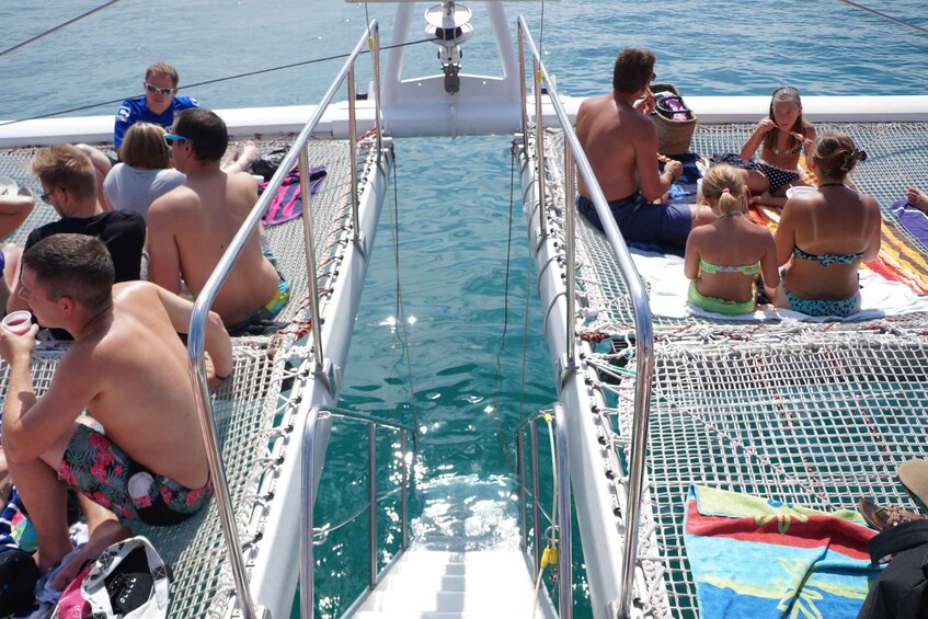 A group of people on a boat with a small pool in the center. 2