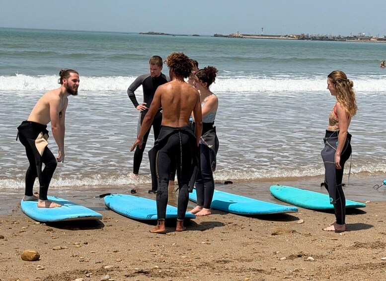 Un grupo de personas en la playa con tablas de surf, preparándose para surfear. 5
