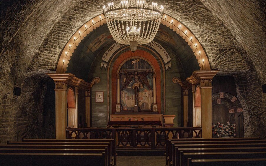An ornate church interior with a large chandelier, arched ceiling, and religious paintings. 3