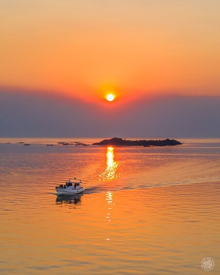 A boat on calm water with a sunset in the background. 5