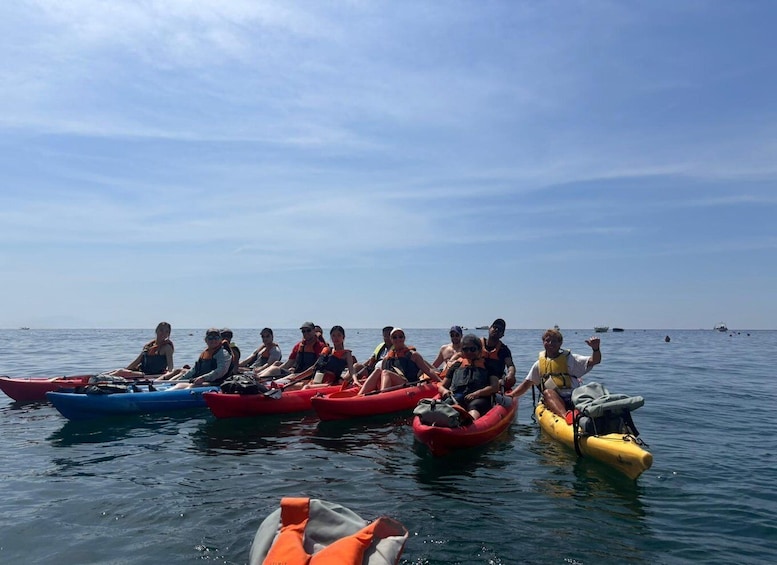 A group of people in kayaks on calm water with a clear sky. 4