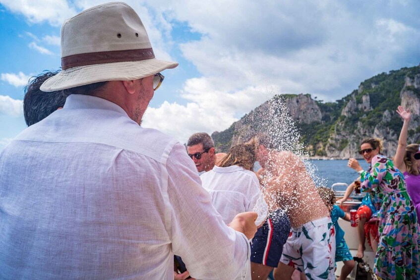 Un gruppo di persone su una barca, con una persona che spruzza acqua verso l'obiettivo. 5