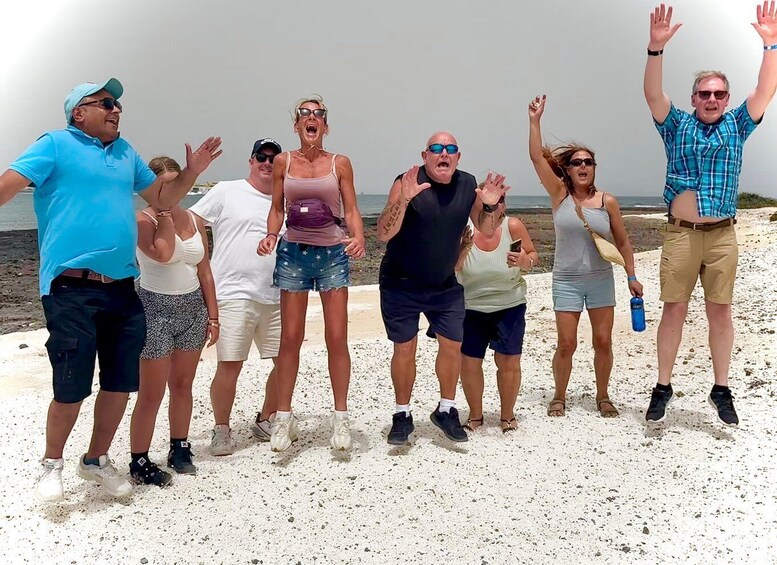 A group of people on a sandy beach with the ocean in the background. 4