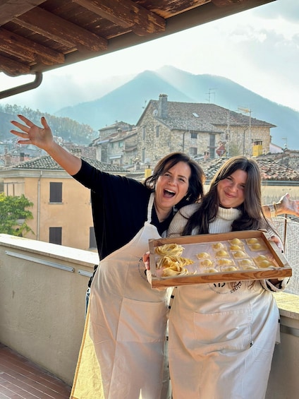 Two people on a balcony with a mountain in the background. 2