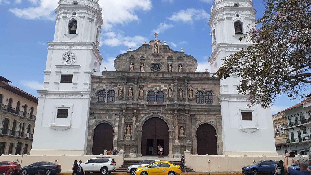 Una iglesia histórica con dos torres de campanas, una fachada central con estatuas y un reloj. 2