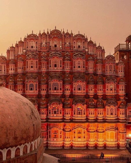 Un grande edificio, finemente decorato con numerose cupole e archi, illuminato al crepuscolo. 1