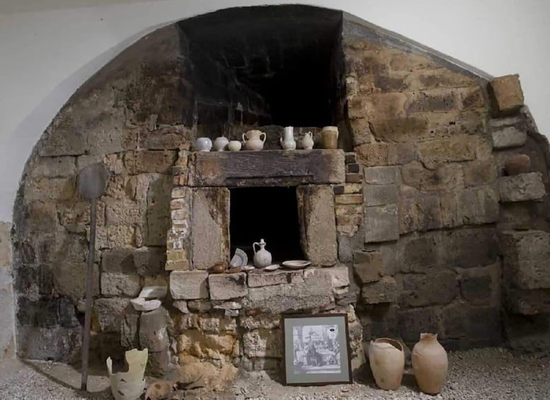 A stone oven with pottery and a framed picture. 3