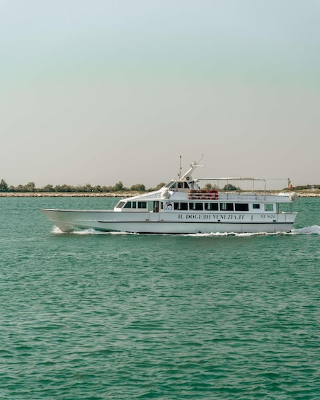 Un bateau blanc portant le nom « IL DOGE DI VENEZIA.IT » et arborant le numéro d’immatriculation « VE 9624 », naviguant sur une étendue d’eau. 1