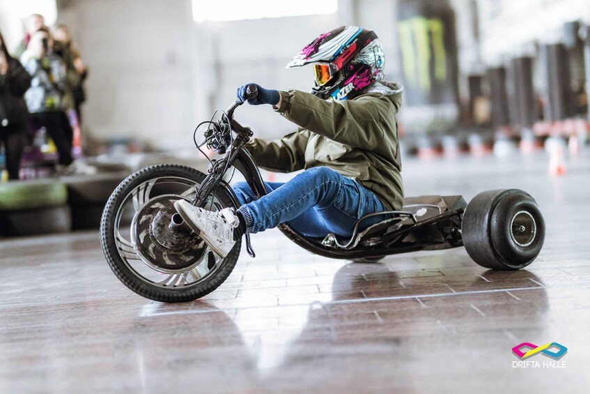 A person riding a three-wheeled vehicle indoors. 2