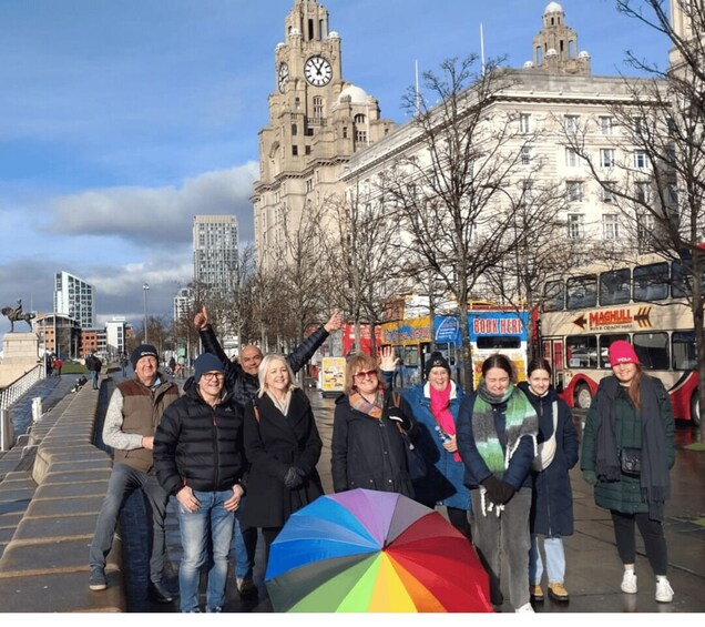 A group of people standing on a city street with a historic building in the background. 5