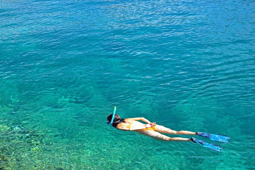 A person snorkeling in clear blue water. 4