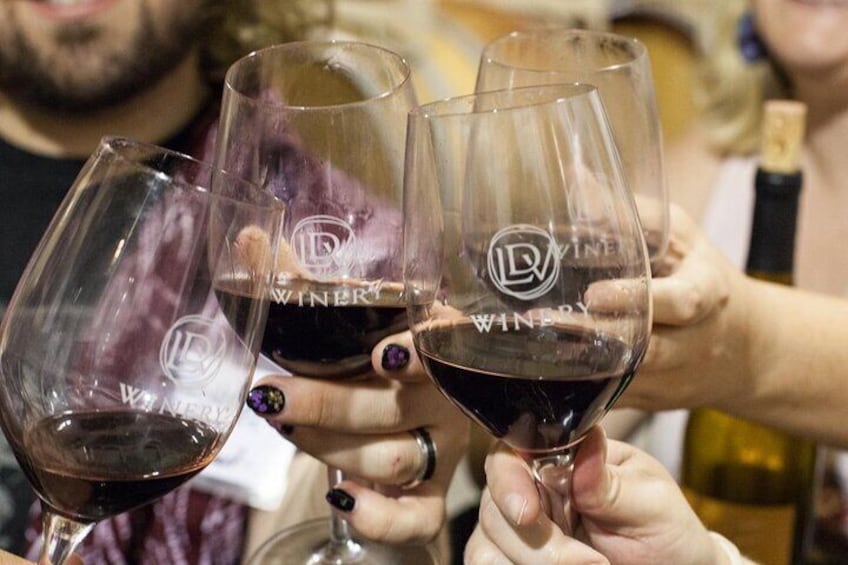 Three wine glasses with 'WINERY' branding being held by people. 1
