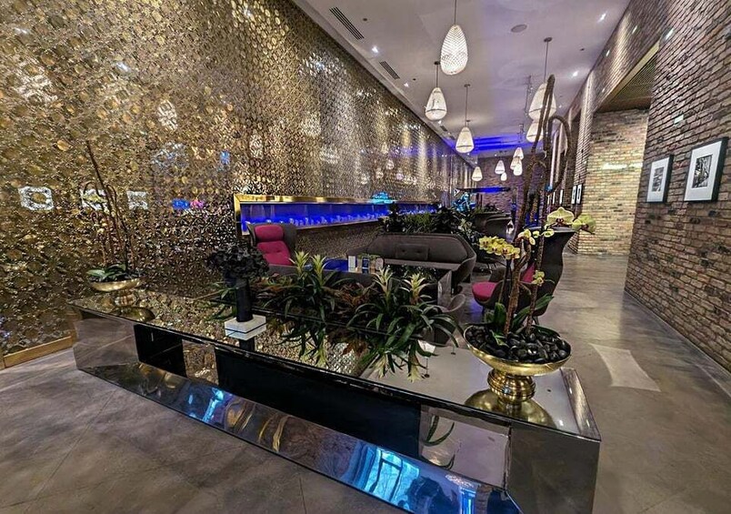 Moderne reception med glasdisk, komfortable siddepladser, dekorative planter og en væg med struktur. 1