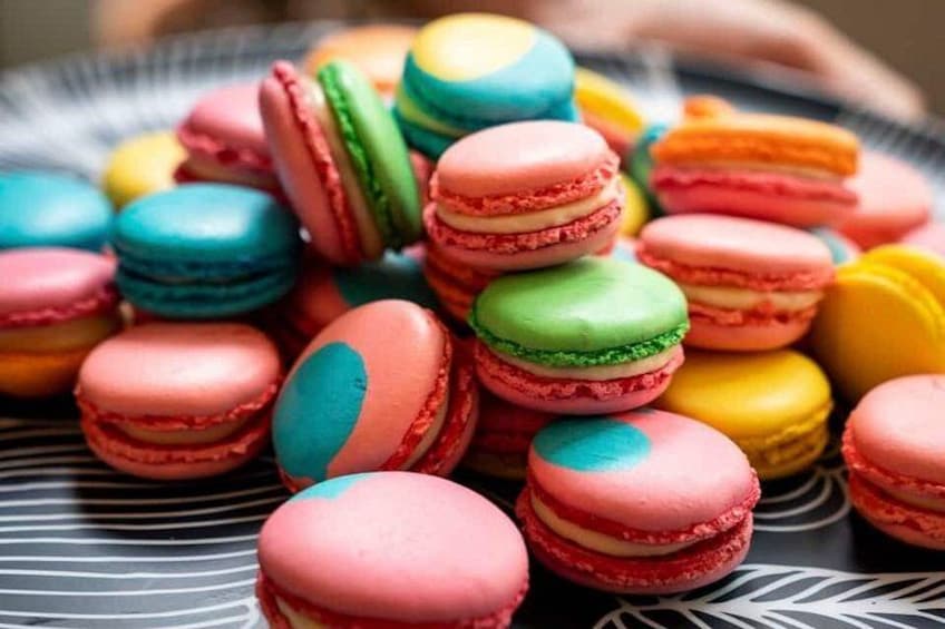 A variety of colorful macarons in a basket. 1