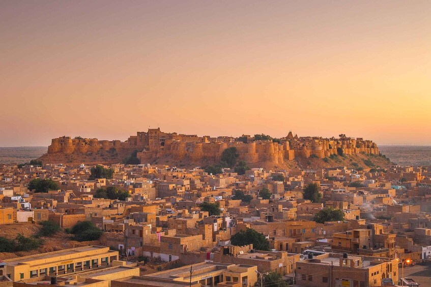 A historic city with a prominent fort on a hill overlooking a densely packed urban area. 4