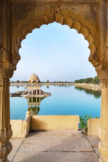 A temple on a lake surrounded by a stone archway. 3