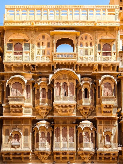 A multi-tiered, intricately carved building with ornate balconies and windows. 2