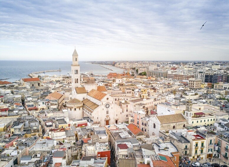 A coastal cityscape with a prominent church and tower, dense urban buildings, and a clear sky. 4