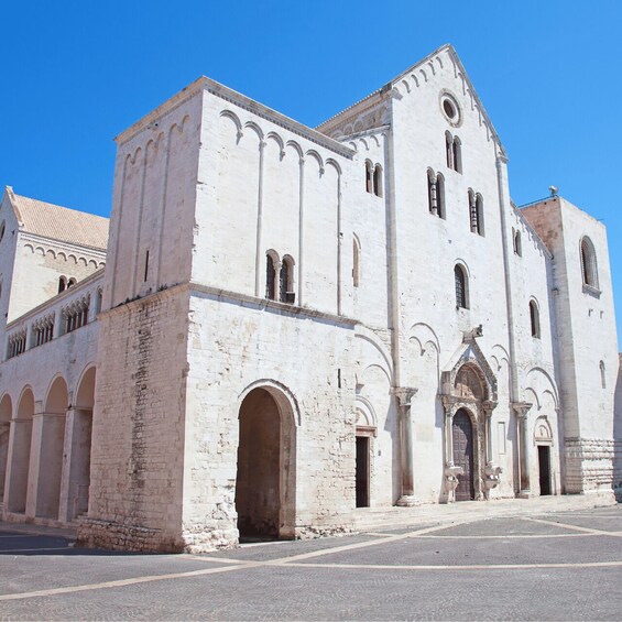 A historic white building with arched windows and a central entrance. 2
