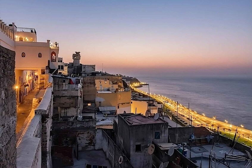 A coastal cityscape at dusk with illuminated streets and buildings. 4