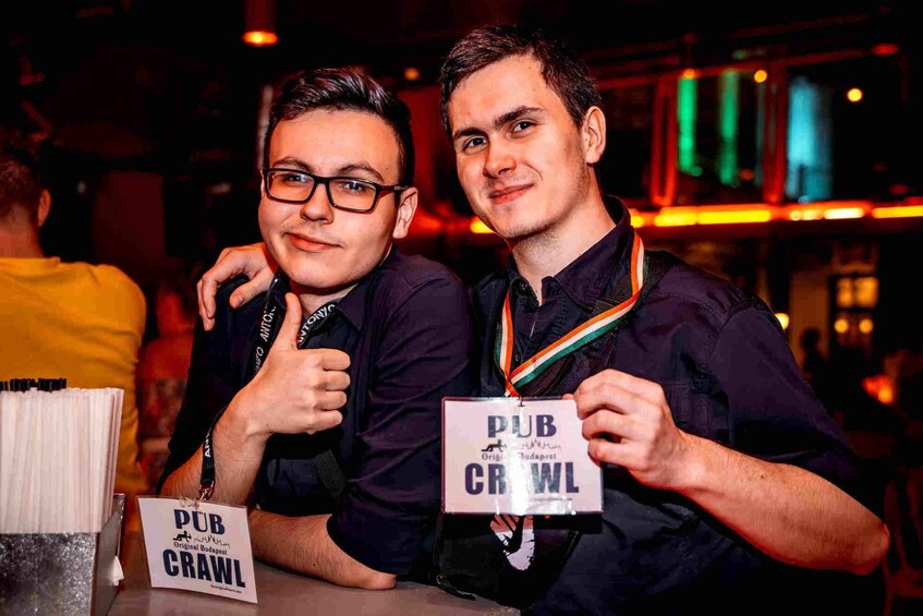 Two people at a pub crawl event, holding signs that read "PUB CRAWL". 5