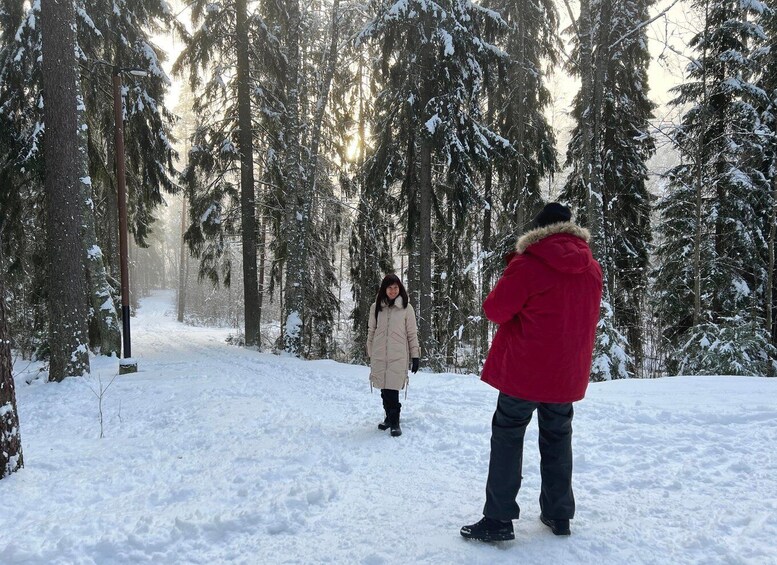 Lumipeitteinen metsä, jossa kaksi ihmistä kävelee. 5