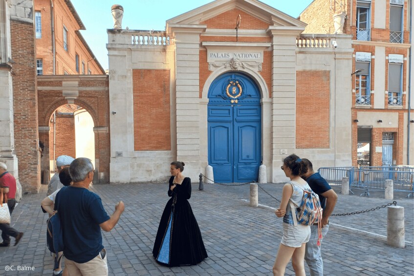 A historic building with a blue door, people walking in front, and a cobblestone street. 3
