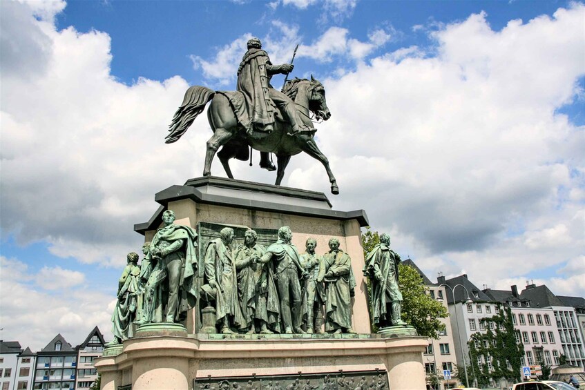 Eine Statue eines Manns zu Pferde mit einer Gruppe von Figuren darunter. 1