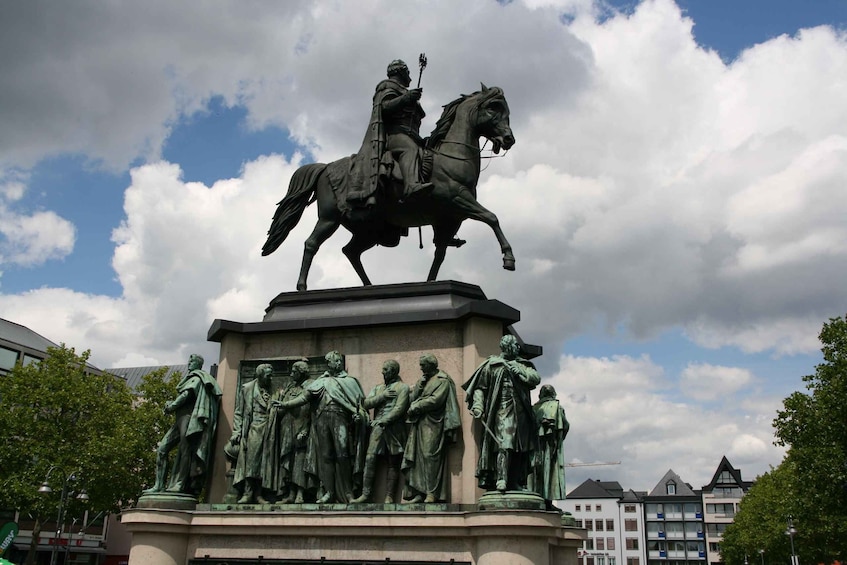 Eine Statue eines Mannes zu Pferd, darunter eine Gruppe von Figuren. 3