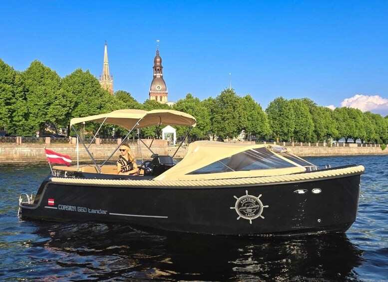 A black boat with a canopy, a red flag, and a church in the background. 2