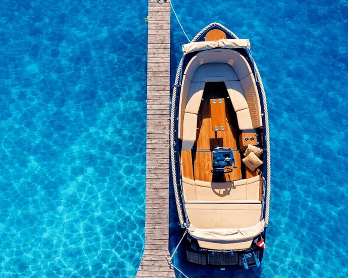 A boat docked at a pier with clear blue water. 4
