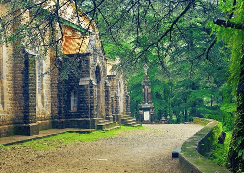 An ancient stone church surrounded by lush greenery. 1