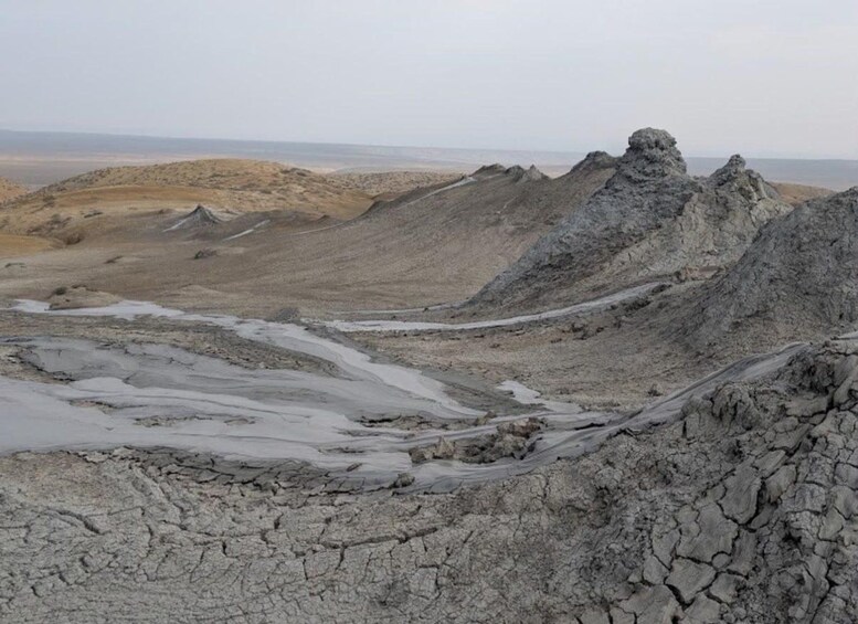 A barren landscape with rocky terrain and a distant view of the sea. 3