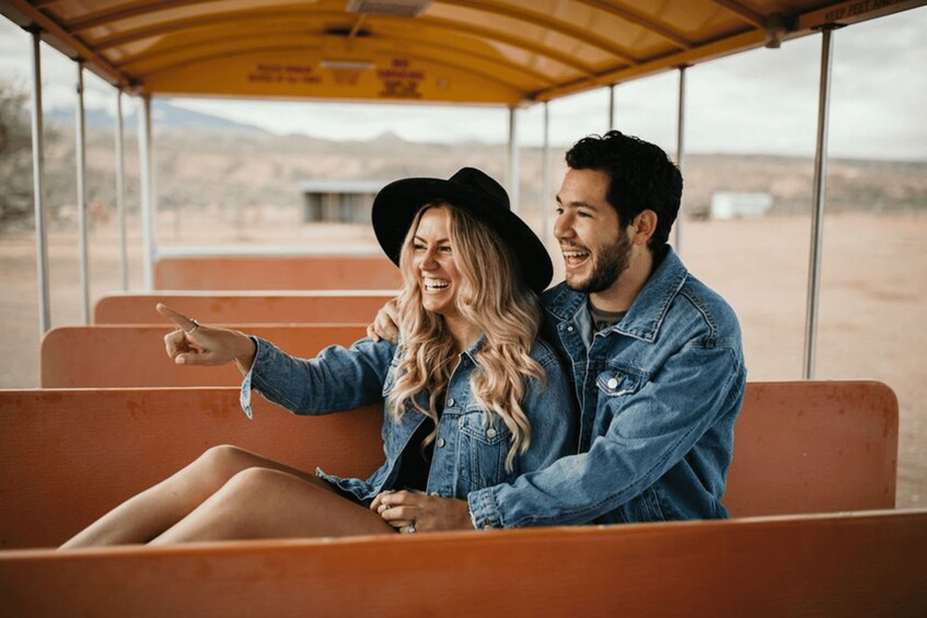 A couple in a vintage bus, pointing out the scenery. 3