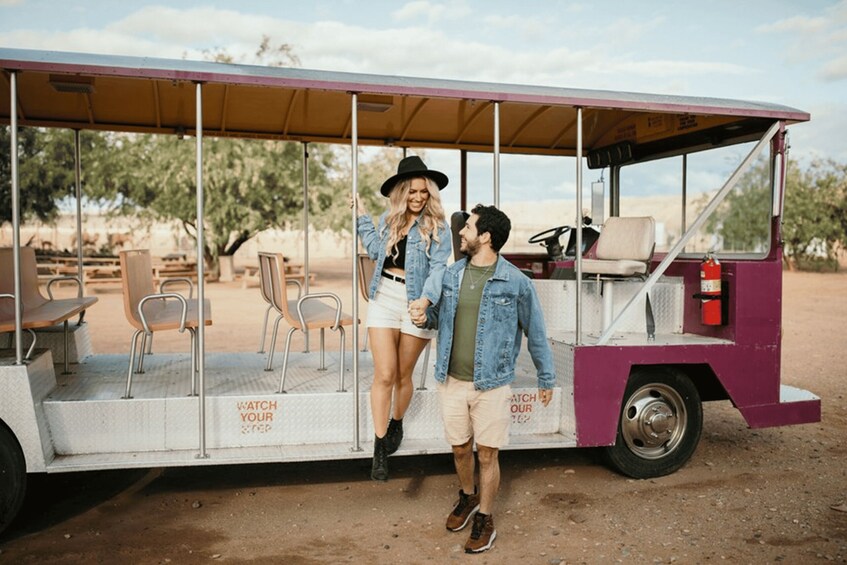 A couple standing in front of a vintage food truck with a sign that reads 'WATCH YOUR STEP.' 1
