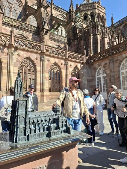 A model of a gothic-style building with intricate architectural details, surrounded by tourists. 3