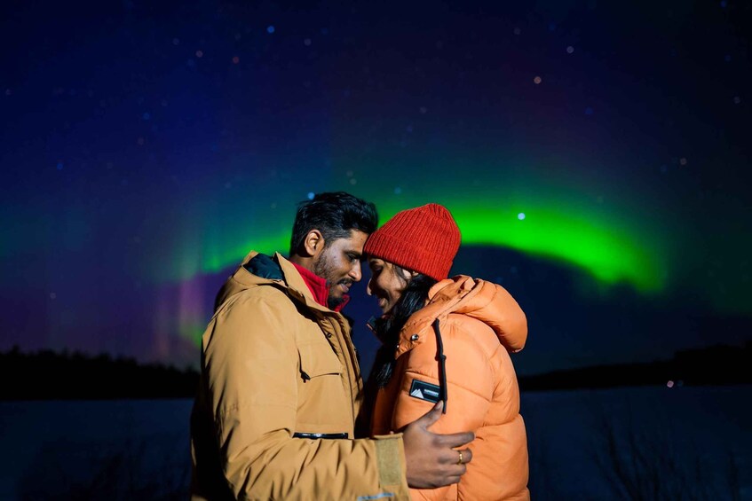 Pari halailee toisiaan tähtitaivaan alla, ja taivaalla näkyy revontulia. 1