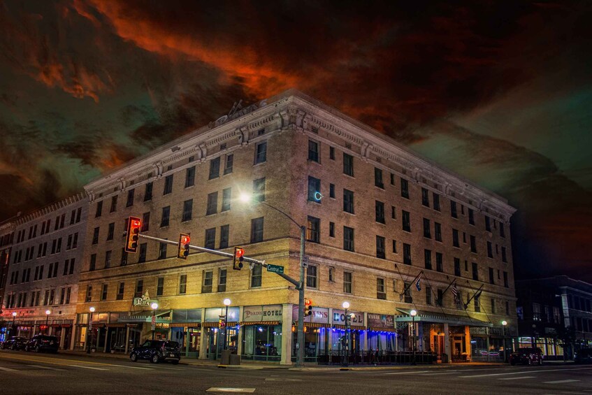 Un edificio histórico con varias fachadas comerciales en la noche. 2