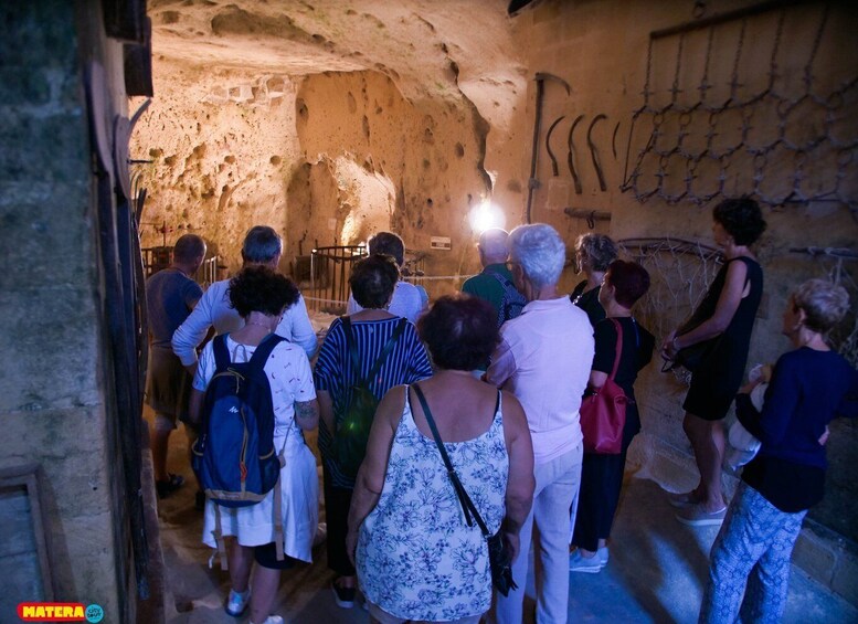 A group of people inside a cave with stalactites and stalagmites. 3