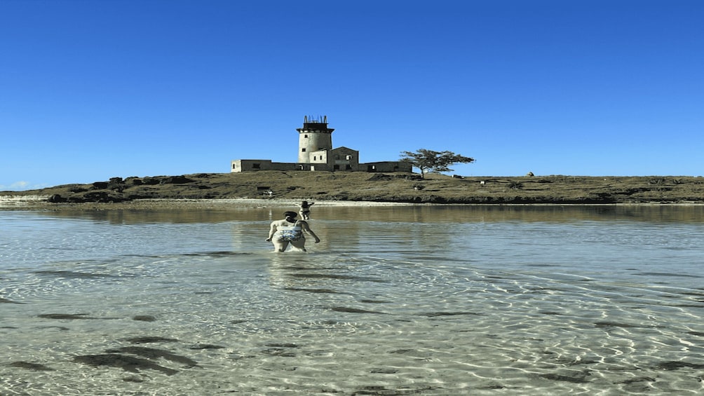 A lighthouse on a rocky shore with clear water. 3