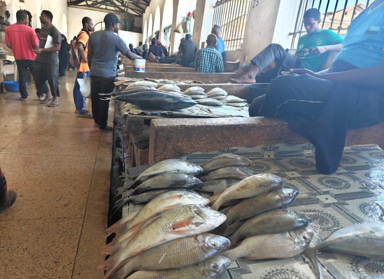 Ein Markt mit auf Tischen ausgelegten Fischen und Einkäufern. 2