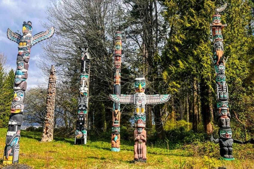 Totem poles with intricate carvings in a forest setting. 1