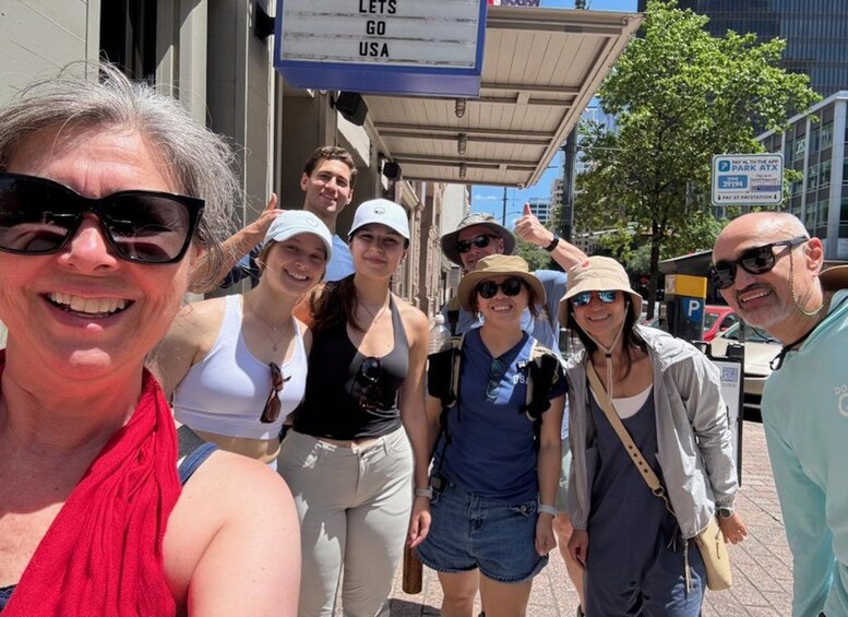 A group of people walking on a city street with a sign that reads 'LETS GO USA' in the background. 3