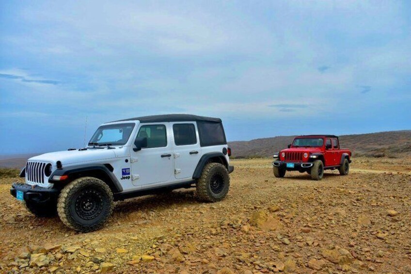 Two off-road vehicles on a rocky terrain with a clear sky. 4