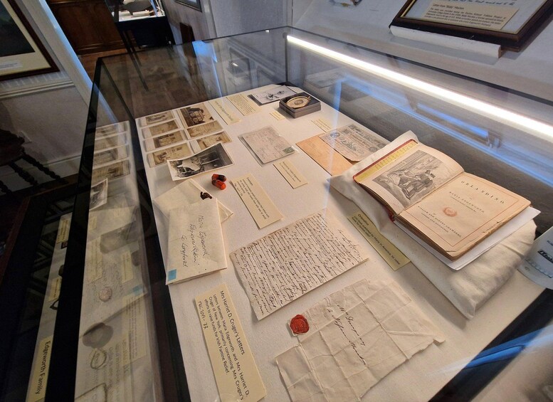Una vitrina con documentos históricos, incluyendo cartas, fotografías y un libro titulado 'ORLANDO'. 4